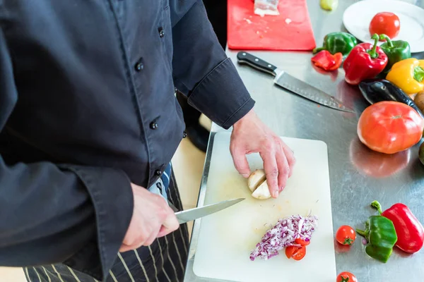 Chef-kok in restaurant keuken snijden uien — Stockfoto