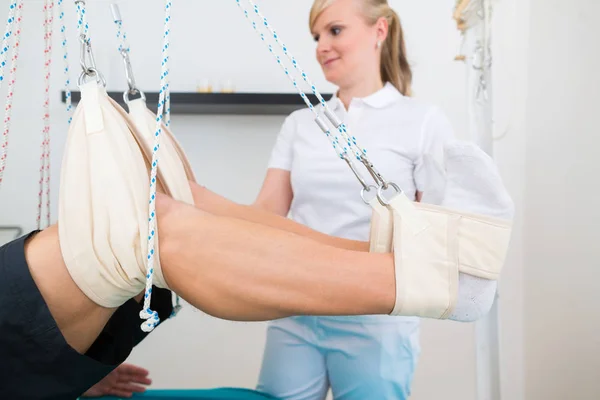 Physiotherapist with patient on sling table — Stock Photo, Image