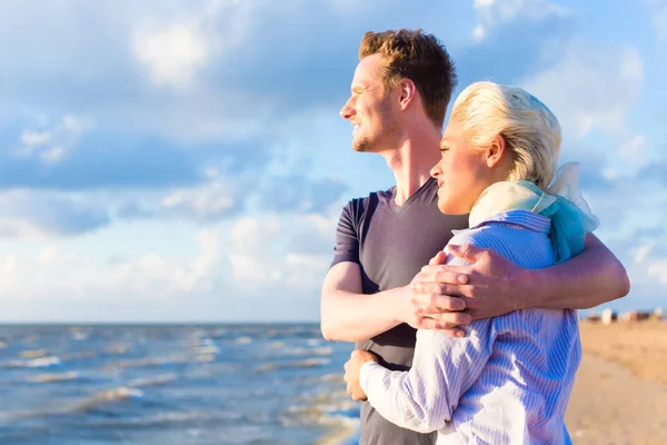 Пара, наслаждающаяся романтическим закатом на пляже — стоковое фото