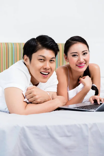 Asijský pár v ložnici surfování po internetu s počítačem — Stock fotografie