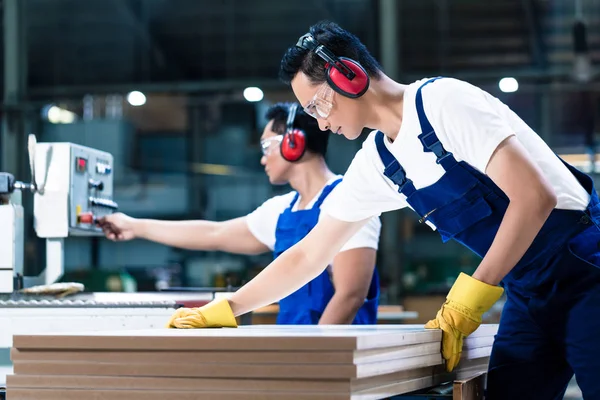 Dois trabalhadores de madeira em tábuas de corte de carpintaria — Fotografia de Stock