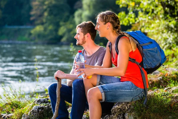 남자와 여 자가 강에서 휴식 하이킹을 데 — 스톡 사진