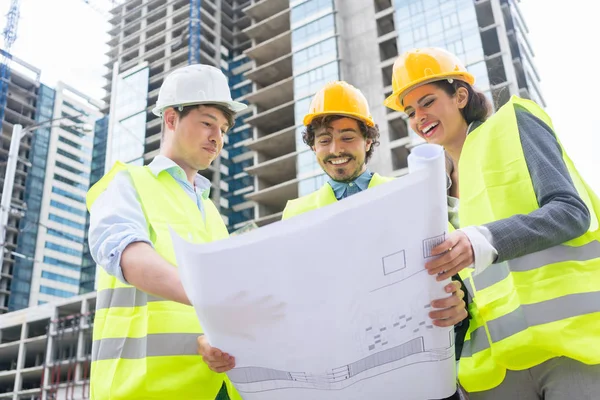 Architects with ground plot on construction site — Stock Photo, Image