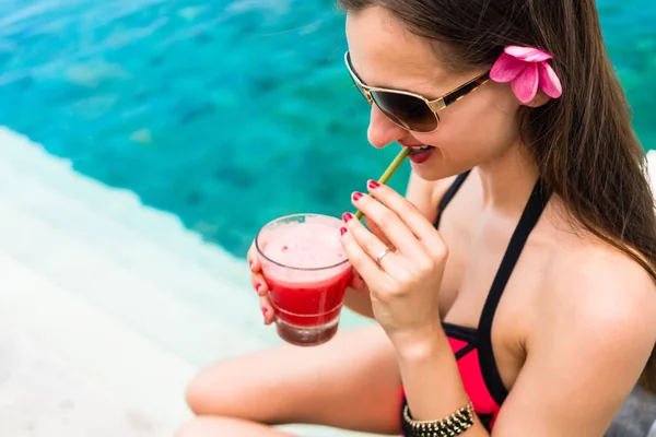 Mujer turista en bikini rojo bebiendo cóctel en la playa —  Fotos de Stock