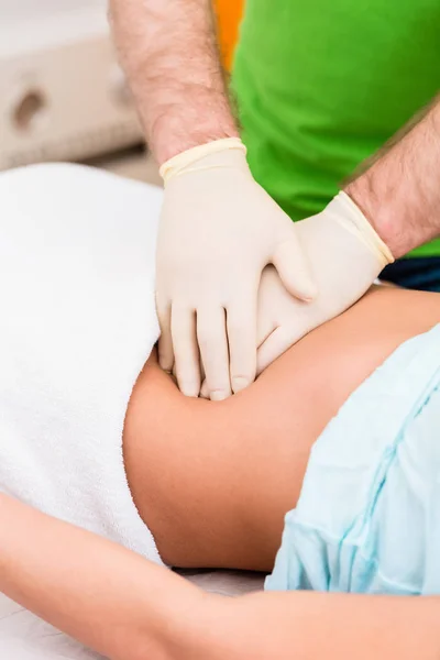 Practicante en terapia de colon masajeando abdomen — Foto de Stock