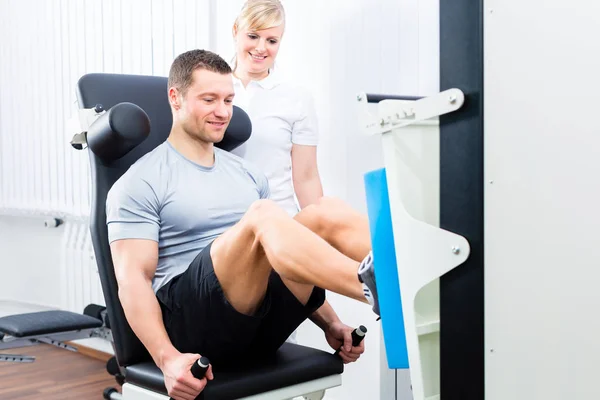 Fisioterapeuta exercitando paciente em terapia esportiva — Fotografia de Stock