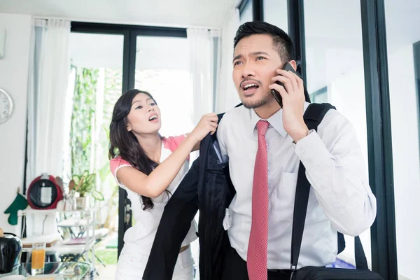 Żona pomaga człowiek spóźnienie się do pracy w kurtce — Zdjęcie stockowe
