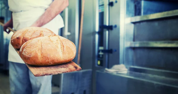 Panettiere in panetteria con pane o — Foto Stock