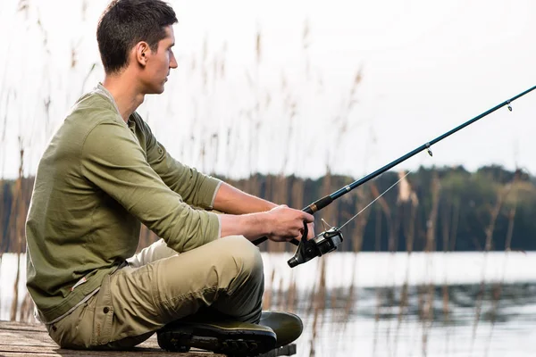 Uomo rilassante pesca o pesca al lago — Foto Stock