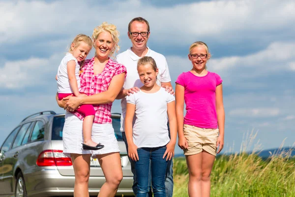 Familie staan samen voor auto — Stockfoto