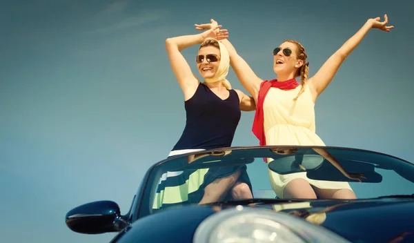 Duas mulheres em carro conversível desfrutando de viagem de carro — Fotografia de Stock