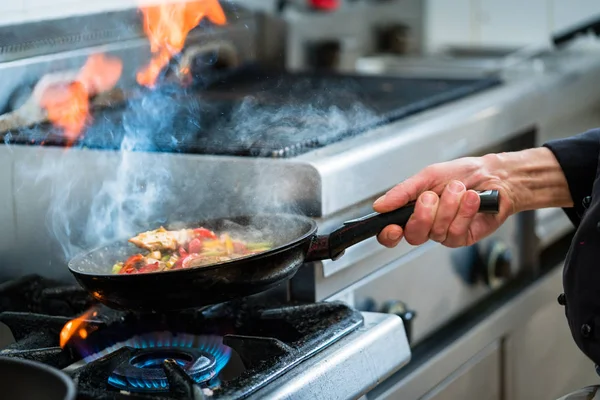 Kuchař dělá flambe na jídlo v pánvi s alkoholem — Stock fotografie