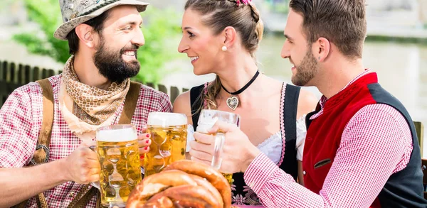 Menschen mit Bier und Brezel in bayerischem Wirtshaus — Stockfoto