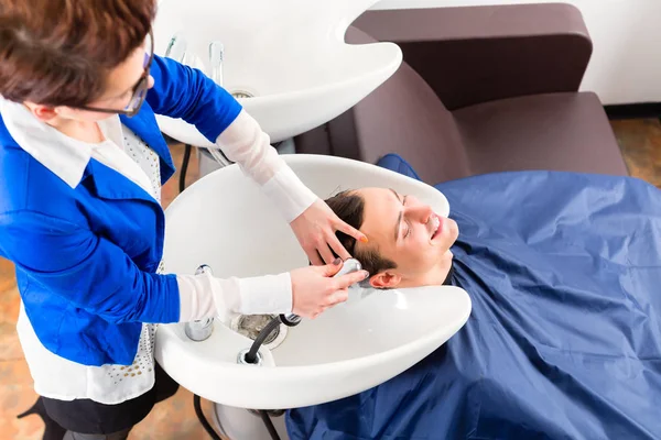 Coiffeur laver les cheveux de l'homme dans le salon de coiffure — Photo