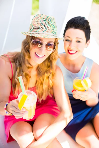 Due amici sulla spiaggia del lago con bevande rilassanti — Foto Stock