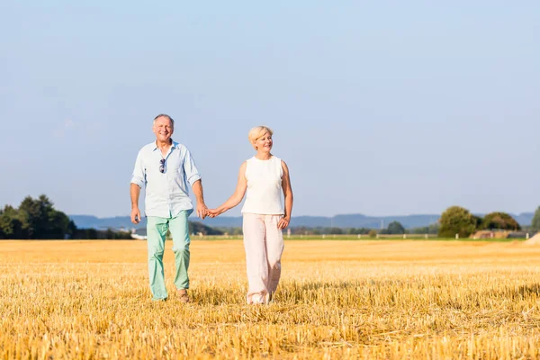 Seniorin und Mann halten sich beim Gehen an Händen — Stockfoto