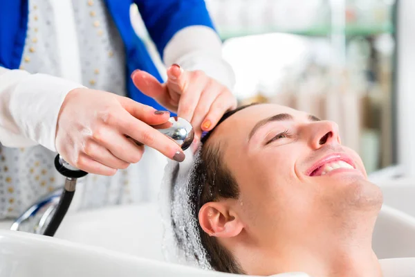 Cabeleireiro lavar o cabelo do homem na barbearia — Fotografia de Stock