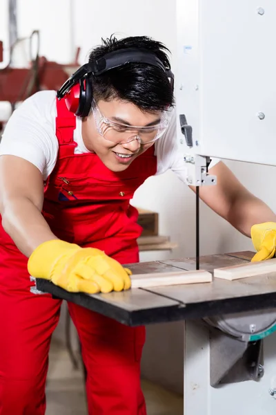 Trabalhador chinês na serra na fábrica industrial — Fotografia de Stock