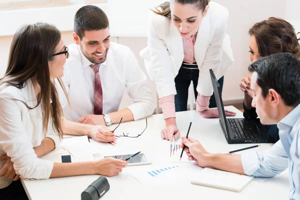 Equipo empresarial analizando datos y discutiendo estrategia —  Fotos de Stock