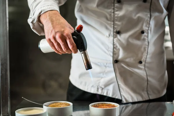 Patissier of chef-kok branden crème brulee doen dessert — Stockfoto