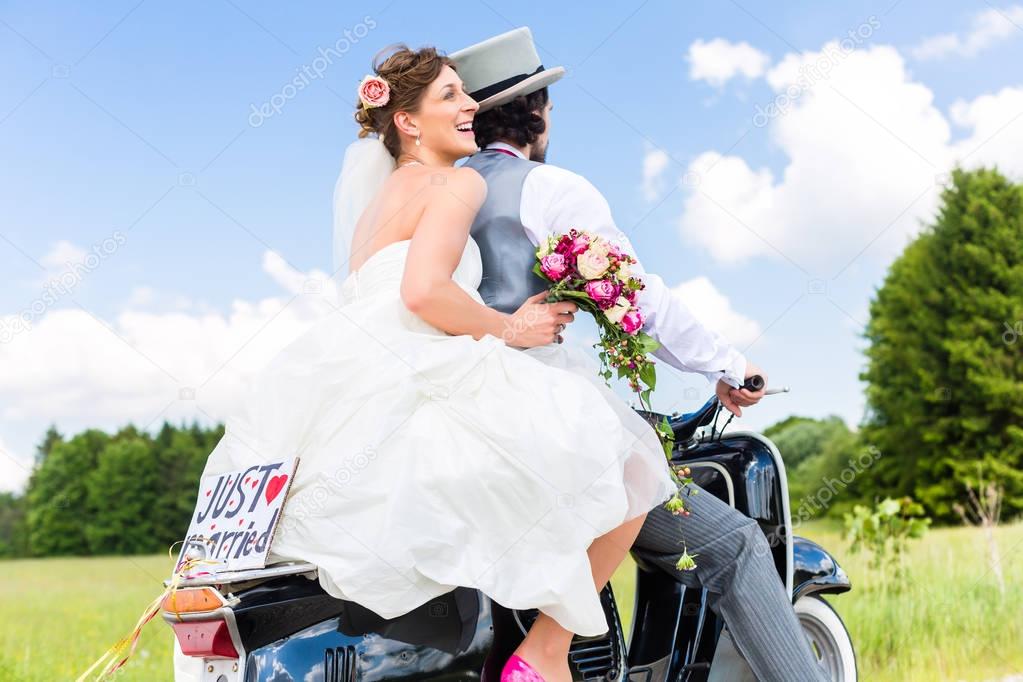 Wedding couple on motor scooter just married
