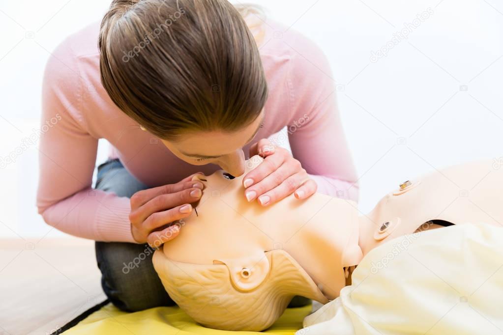 Woman training mouth-to-mouth breath