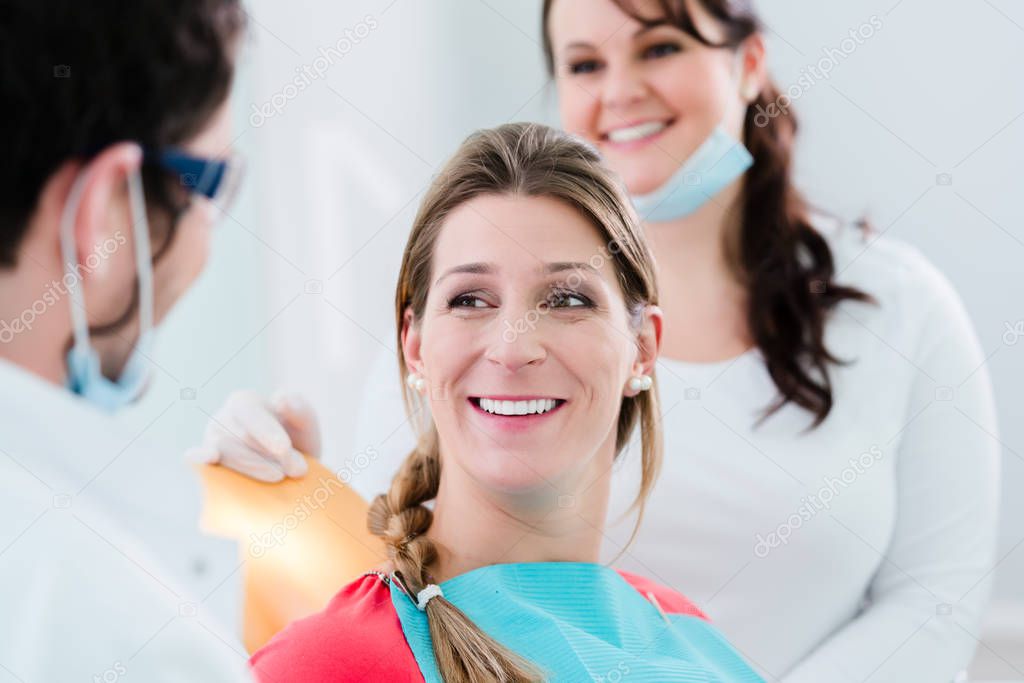 Woman with dentist and nurse smiling