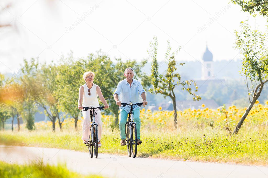 Senior couple, woman and man, riding their bikes