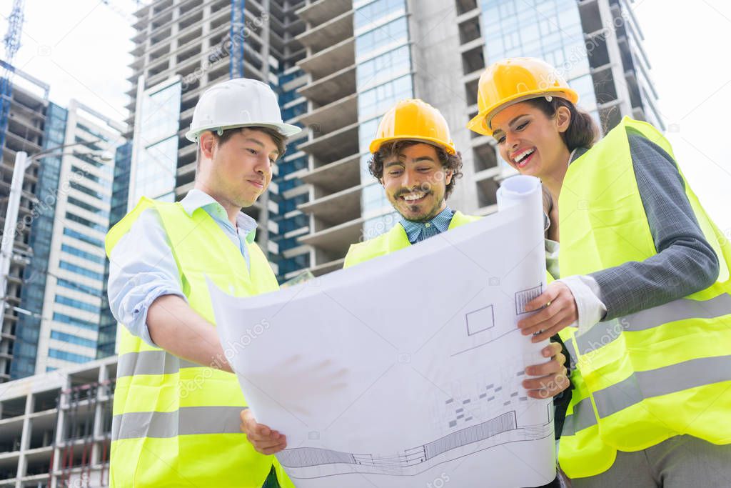 Architects with ground plot on construction site