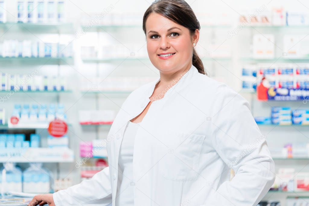 Pharmacist in chemist shop looking at camera