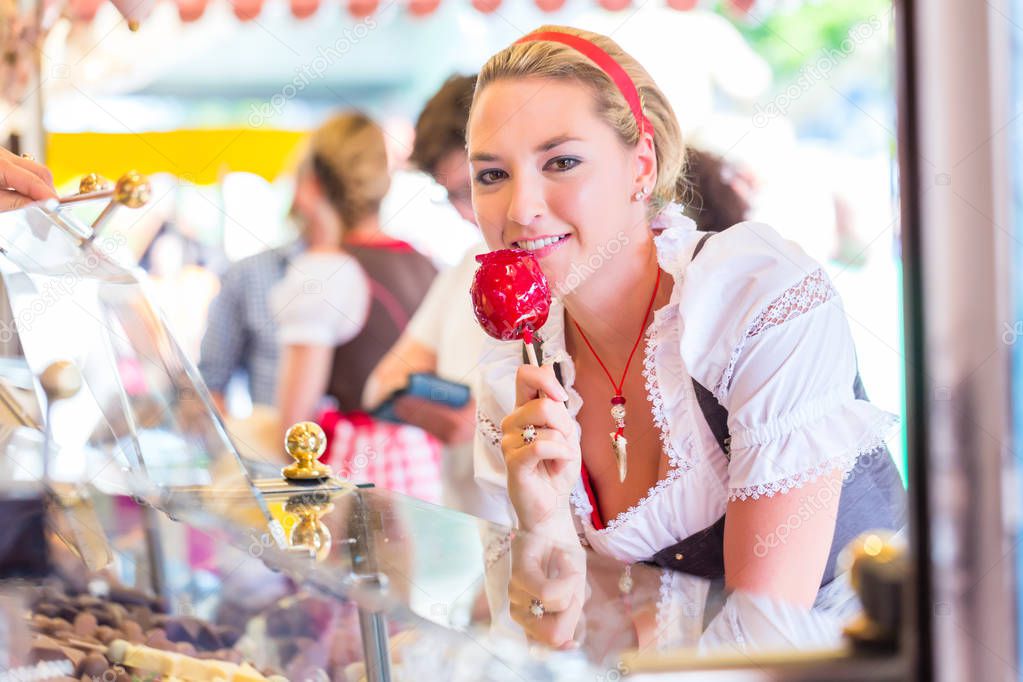 Woman eating candy apple at Oktoberfest or Dult
