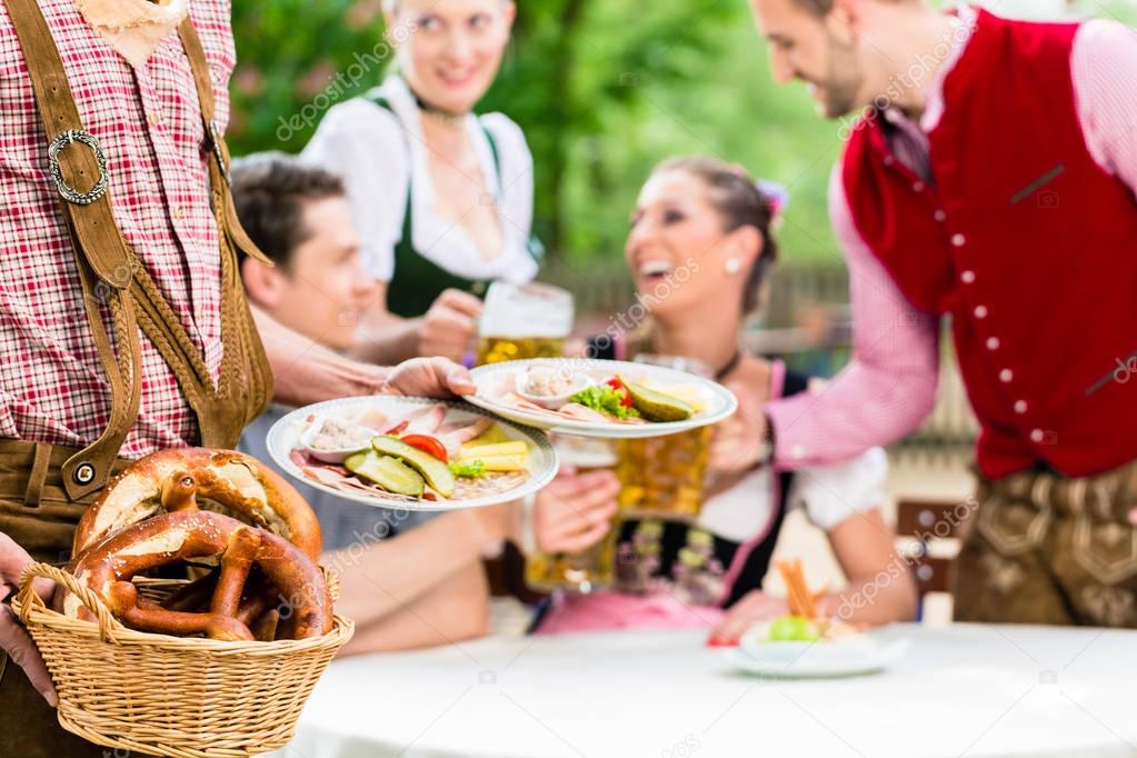 Waiter serving food in Bavarian beer garden