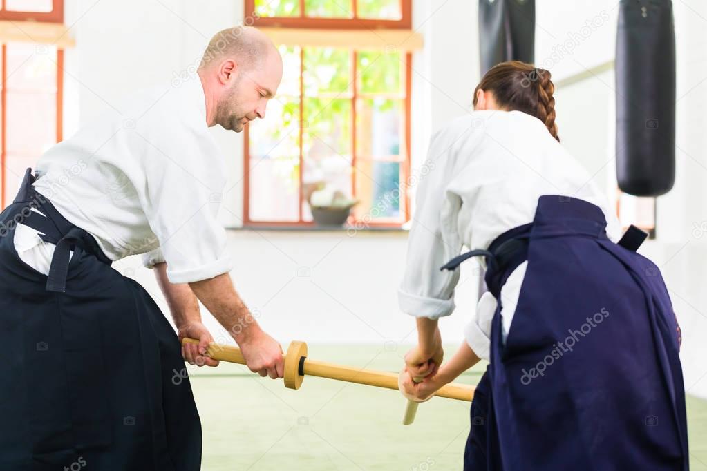 Man and woman having Aikido sword fight 