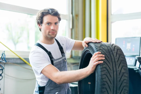 Auto mechanik mění pneumatiky — Stock fotografie