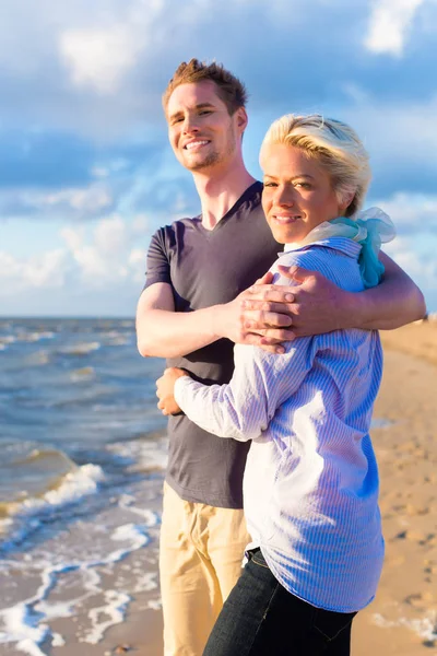 Pár, kteří požívají romantický západ slunce na pláži — Stock fotografie
