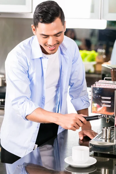 Азиатский мужчина делает эспрессо на кухне — стоковое фото