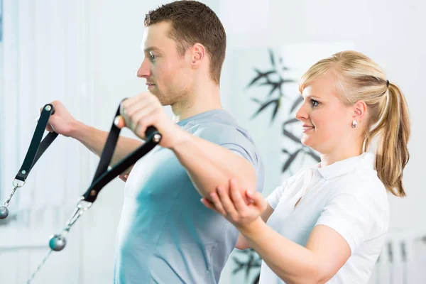 Fisioterapeuta haciendo ejercicio al paciente en la práctica —  Fotos de Stock