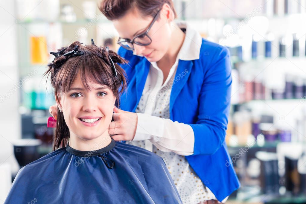 Hairdresser styling woman hair 