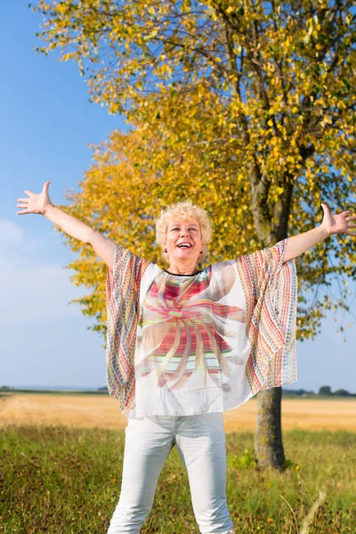 Mujer mayor con los brazos extendidos —  Fotos de Stock