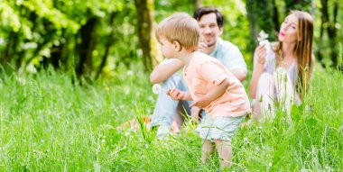 Küçük çocuk çayır üzerinde çalışan