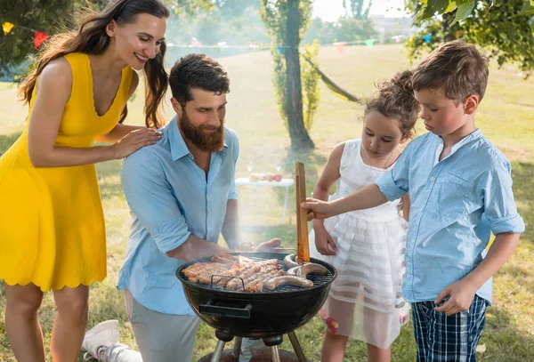 Familia cerca de parrilla barbacoa —  Fotos de Stock