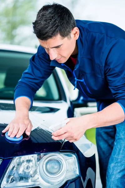 Young man waxing car — Stock Photo, Image