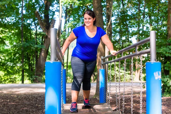 Mujer con sobrepeso en parque de escalada — Foto de Stock