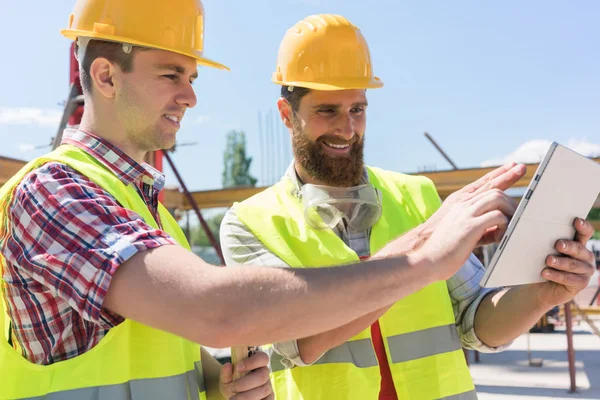 Dos jóvenes trabajadores viendo vídeo — Foto de Stock