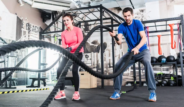 Kvinna och man i gymmet — Stockfoto