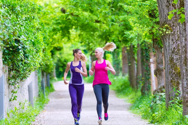 Young women running on alley — Stock Photo, Image