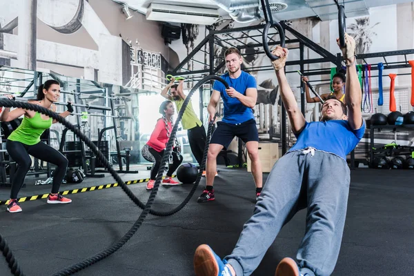 Young men and women in gym — Stock Photo, Image