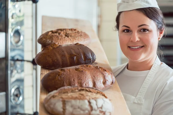 Baker-vrouw presentatie van brood — Stockfoto