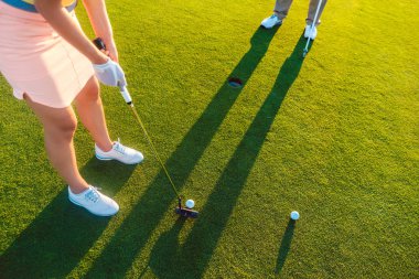 Yüksek-açı eşi putter golf sopasıyla sahip bir kadın oyuncu görünümünü kırpılmış 