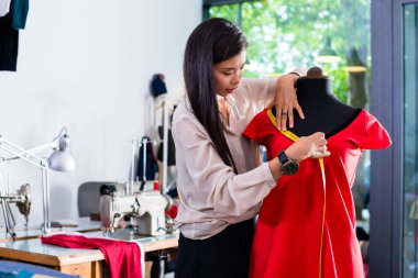 Asya terzi onun atölyesinde manken giysi tasarımı ayarlar